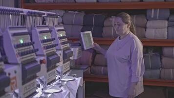 industrial workshop for the production of fabric. factory. Media. Woman worker at the automatic mechanism at the factory. video