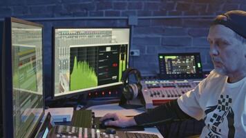 Man at remote control of recording studio. Media. Elderly man in recording booth. Music producer at recording studio console video