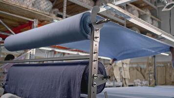Details of a workshop of textile fabric. Media. Rolls of blue fabric at the textile factory. video