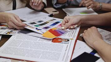 Designers are thinking and designing clothes for customers at the desk in the studio. Media. Women workers choosing colors of clothes. video