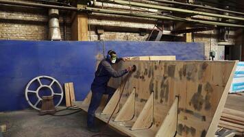 A dedicated Craftsman Skillfully Working on a Wood Structure inside his Workshop. Stock Clip video