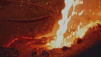 Moving stream of molten metal. Stock footage. Molten metal or lava is moving in riverbed. Stream of red-hot liquid with splashes video