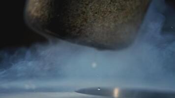 Hot water being poured out of bucket. Stock footage. Close-up of jet of water pouring out of small bucket. Hot clean water is poured from ladle into metal container with steam video