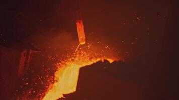 Streams and channels of molten metal. Stock footage. Worker crushes place for molten metal to flow with metal shelf. Solidified metals in path of molten alloy video