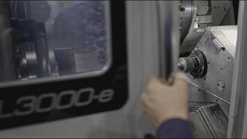 Worker closes metalworking machine at factory. Stock clip. Worker closes door of processing center. Worker closes doors of closed automated machine at factory video