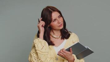 Thoughtful journalist woman making notes, writing down thoughts with pen into notepad notebook diary video