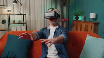man använder sig av virtuell verklighet trogen teknologi headsetet till spela simulering 3d spel på Hem video