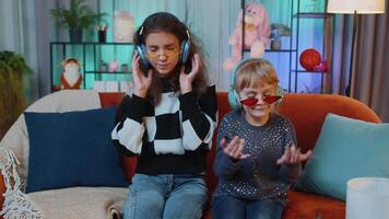 Siblings children girls listening music, dancing disco fooling around having fun, relaxing on party video