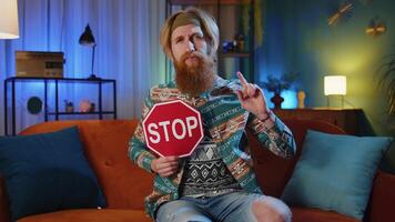Man say no hold showing stop inscription banner warning of finish, prohibited access, danger at home video
