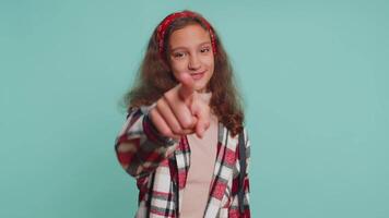 Child girl pointing to camera and looking with happy expression, making choice, showing direction video
