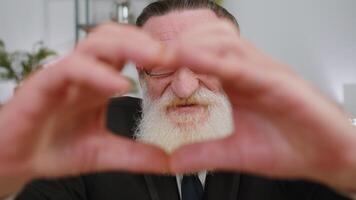 Senior business man makes symbol of love, showing heart sign to camera, express romantic feelings video