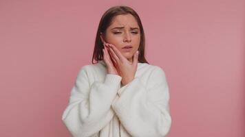 Woman touching cheek suffering from toothache cavities or gingivitis waiting for dentist appointment video