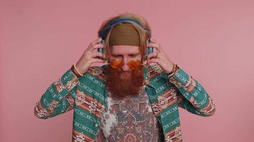 Hippie redhead man listening music and dancing disco fooling around having fun relaxing on party video
