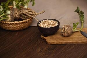 Fresh celery with tops and roots, chopped dried version in a bowl with copy space photo
