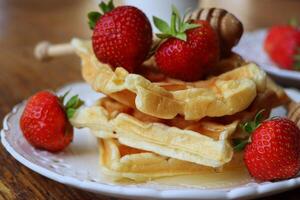 Belgian waffles with fresh berries strawberry , honey and cappuccino coffee for breakfast photo