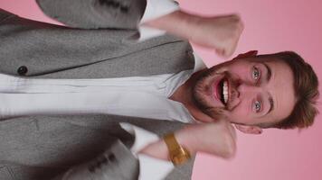 Handsome business man shouting, raising fists in gesture I did it, celebrating success, winning video