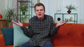 Young man man asking why, what reason of failure, demonstrating disbelief irritation by troubles video