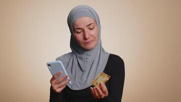 Young woman use credit bank card and smartphone while transferring money, purchases online shopping video