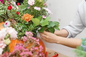 Creating a floral composition in a pumpkin. Making decor with your own hands. photo