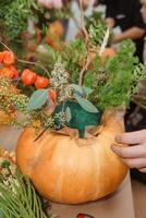 Creating a floral composition in a pumpkin. Making decor with your own hands. photo