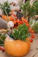 Creating a floral composition in a pumpkin. Making decor with your own hands. photo