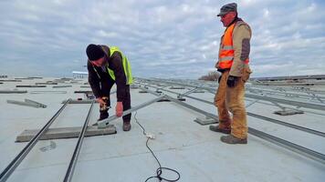 Workers installing solar panels. Installing solar photovoltaic panel system video