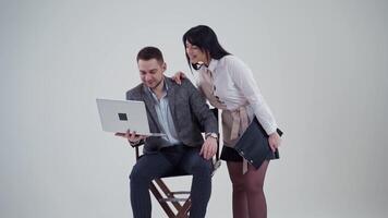 Studio portrait of business couple. Young business colleagues couple isolated over white wall background using laptop computer video