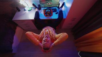 Top view of man driving simulator. Young man with pc computer playing car racing game at home video