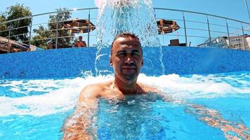 Man refreshing on vacation. Selfie shot of man in water surface at pool video