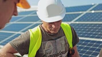 Worker standing in solar power station. Portrait of handsome engineer in protective helmet video
