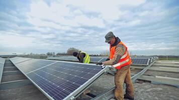 Workers installing solar panels outdoors. Man installing alternative energy photovoltaic solar panels video