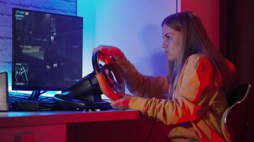 Gamer plays game. Girl with joystick playing racing game in room at night video