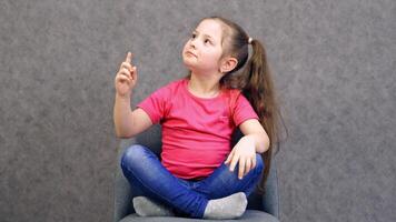 Portrait of exited and happy girl. Girl pointing finger up with successful idea video