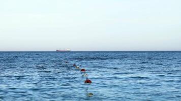 Floating buoy on blue sea. Lots of empty red mooring buoys floating on water video