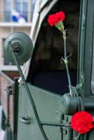 two red carnations decorating a military vehicle during the commemoration of April 25th in Portugal. Revolucao dos Cravos. photo