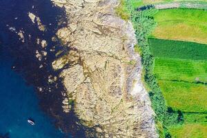 edge of a rocky shore, aerial view with a rocky shore of a rocky coast and agricultural fields, aerial view with drone, background for marine concept photo
