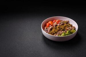 Quinoa bowl with tofu, steamed vegetables, grains, seeds and spices photo