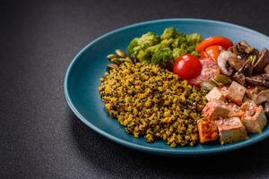 Quinoa bowl with tofu, steamed vegetables, grains, seeds and spices photo