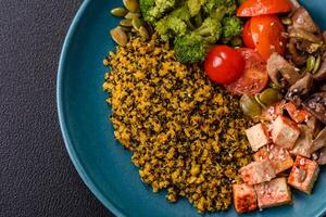 Quinoa bowl with tofu, steamed vegetables, grains, seeds and spices photo