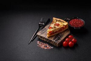 Delicious crispy quiche cut into slices with cheese, broccoli, tomatoes photo