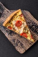 Delicious crispy quiche cut into slices with cheese, broccoli, tomatoes photo