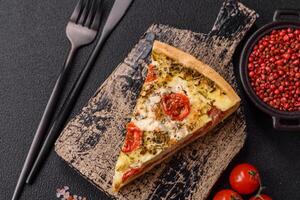 Delicious crispy quiche cut into slices with cheese, broccoli, tomatoes photo