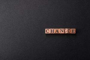 The inscription chance or change with wooden cubes on a dark concrete background photo