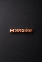 The inscription chance or change with wooden cubes on a dark concrete background photo