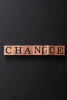 The inscription chance or change with wooden cubes on a dark concrete background photo