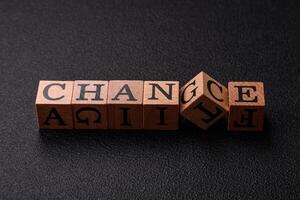 The inscription chance or change with wooden cubes on a dark concrete background photo