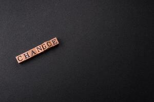 The inscription chance or change with wooden cubes on a dark concrete background photo