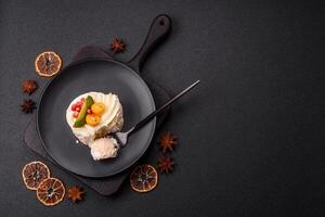 Piece of sweet meringue with citrus, kiwi and pomegranate seeds photo