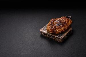 Juicy pork steak baked on the grill with salt, spices and herbs photo