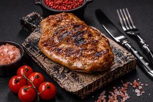 Juicy pork steak baked on the grill with salt, spices and herbs photo